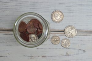 Picture showing various US coins on a table and in a jar.